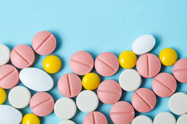 Mavi arka planda bir sürü renkli hap makrosu.