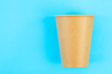 Kahve, çay ve mavi arka planda bulunan çevresel malzemelerden elde edilen bir içecek için tek kullanımlık kahverengi kağıt bardak..