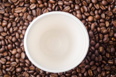 Kahve çekirdeğinin arka planında boş kağıt kahve fincanı..