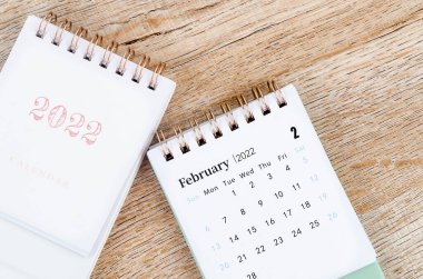 Tahta zemin üzerinde mini Şubat 2022 masa takvimi.