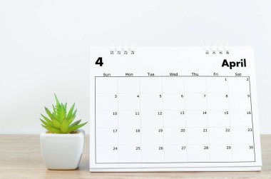 Nisan 2022 Ahşap masadaki saksıda küçük bitkilerle dolu masa takvimi.