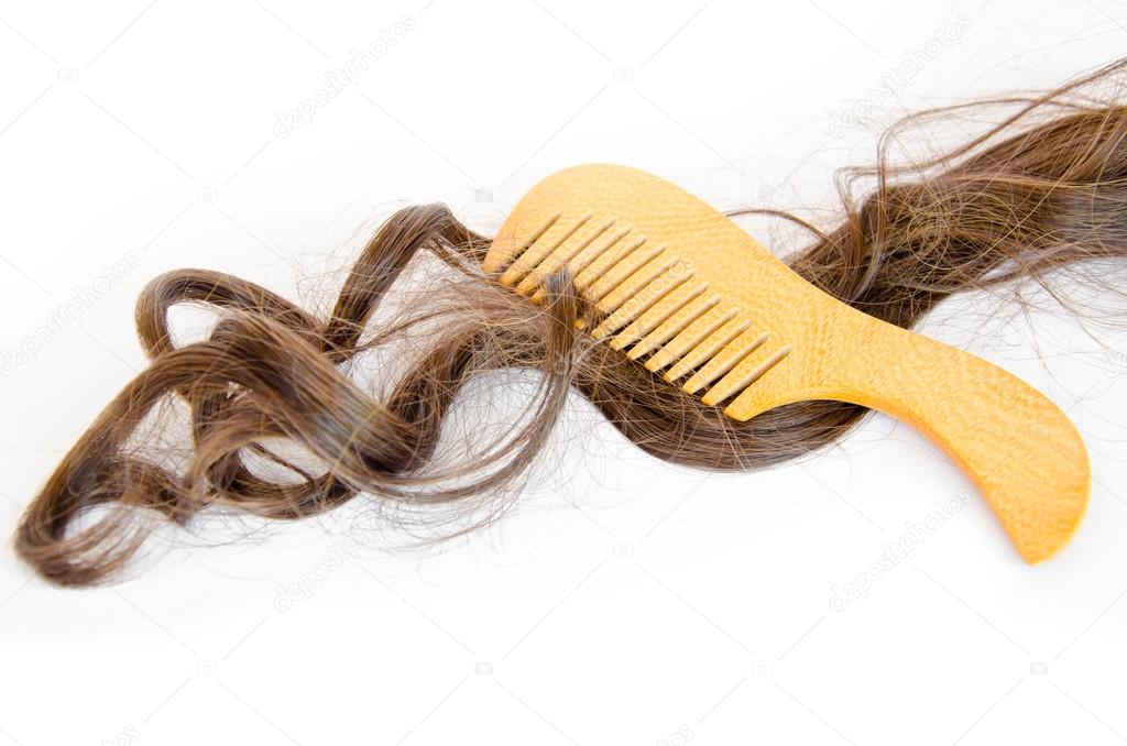 wooden comb brush with long hair, on white background