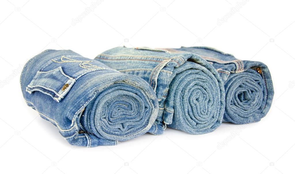 roll blue denim jeans arranged on white background
