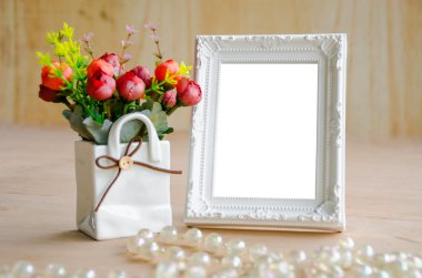 çiçek vazo ve boş beyaz resim çerçevesi üzerinde ahşap