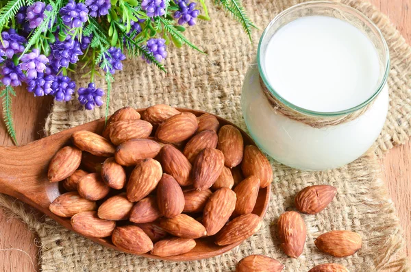 Almonds in wooden spoon and almonds milk. — Stock Photo, Image