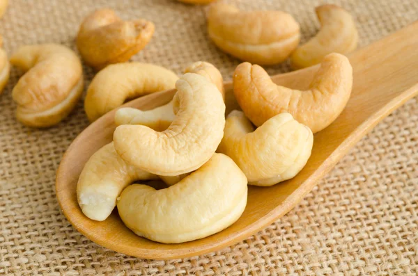 Cashews close-up in wooden spoon. — Stock Photo, Image