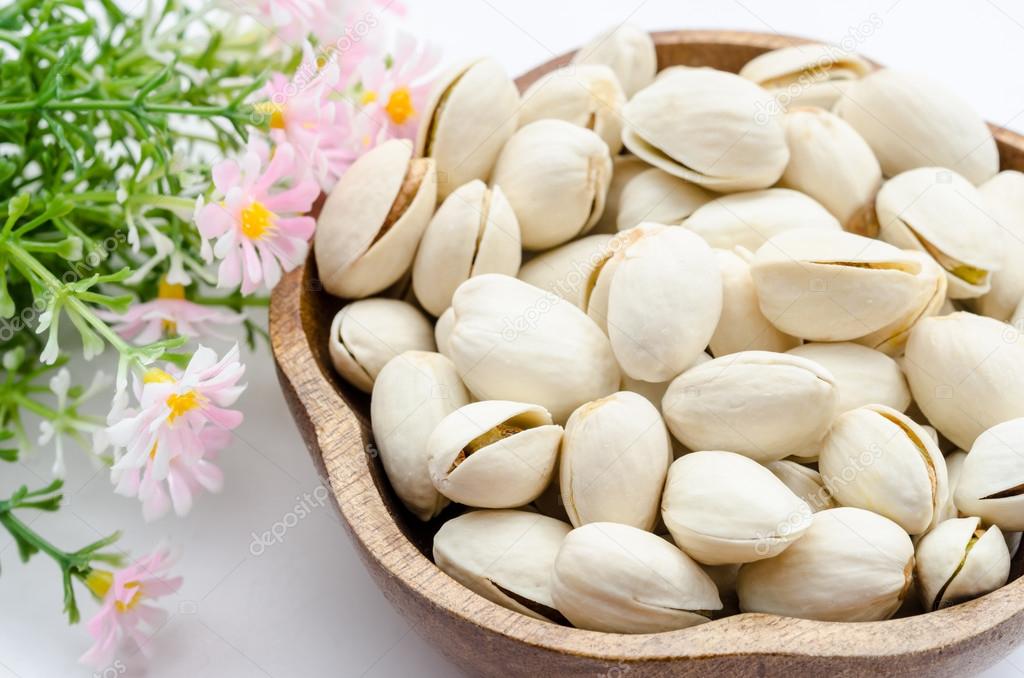Pistachios nuts in a wooden bowl 