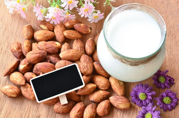 Almond and almond milk with blank black wooden tag for your text — Stock Photo, Image