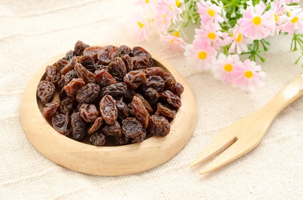Raisin on wooden dish and wooden fork spoon. — Stock Photo, Image