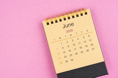 Pembe arka planda Haziran 2026 için kahverengi masa takvimi.