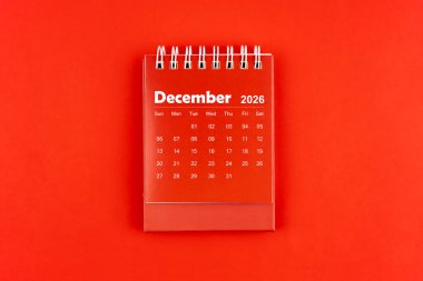 Aralık 2026 kırmızı masa takvimi kırmızı zemin üzerinde, düz yatıyordu.