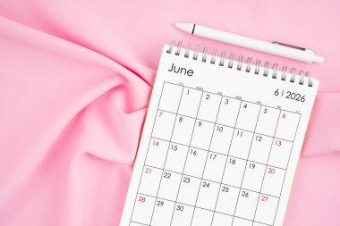 Haziran 2026 takvim ve pembe kumaşlı kalem. Aylık takvim kavramı.