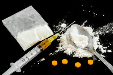 İlaç şırınga, amfetamin tabletler ve pişmiş eroin.