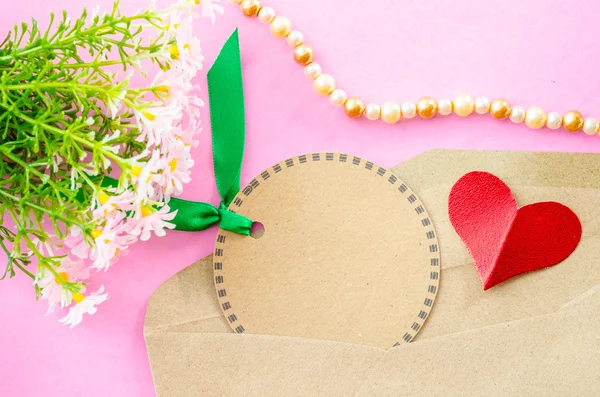 Etiqueta de papel marrón en blanco y papel rojo corazón con flor . — Foto de Stock