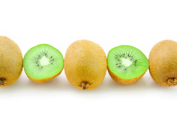 Reihe frischer Kiwi-Früchte und halbe Kiwi auf weißem Hintergrund. — Stockfoto