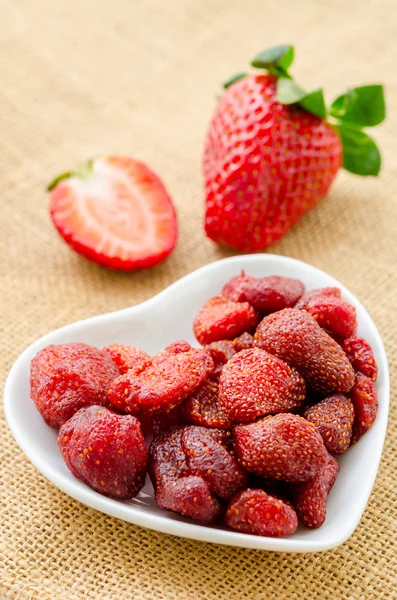 Getrocknete Erdbeeren in weißer Schüssel und frische Erdbeeren. — Stockfoto