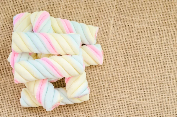 Twisted marshmallow on sack background. — Stock Photo, Image