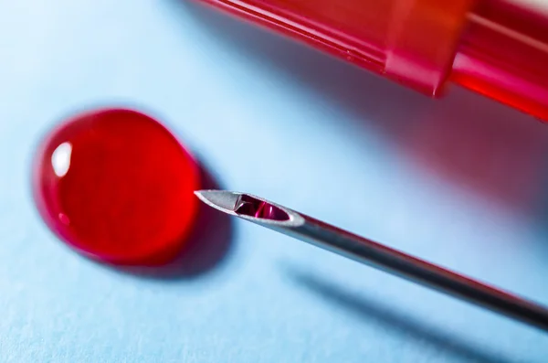 Extracted blood in syringe with hypodermic needle, blood drops. — Stock Photo, Image