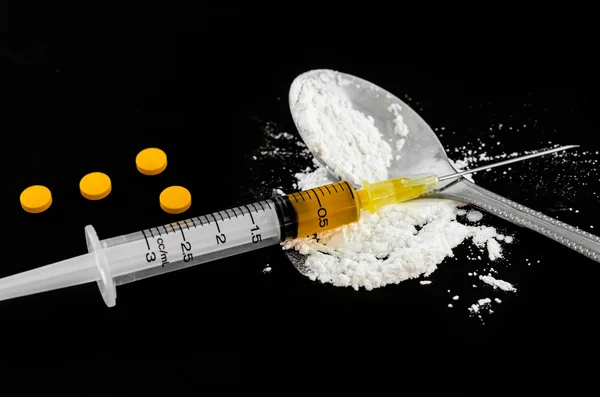 Jeringa para drogas, tabletas de anfetamina y heroína cocida . — Foto de Stock