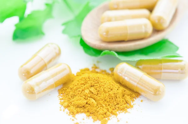 Turmeric herbal capsules with green leaf. — Stock Photo, Image