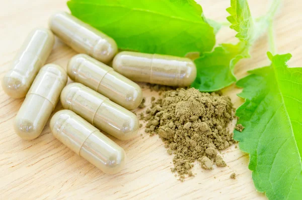 Hierbas medicinales en polvo y cápsulas con hoja de hierba orgánica verde —  Fotos de Stock