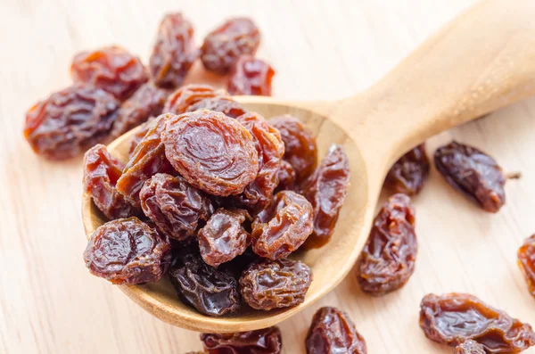 Red raisins in a wooden spoon. — Stock Photo, Image