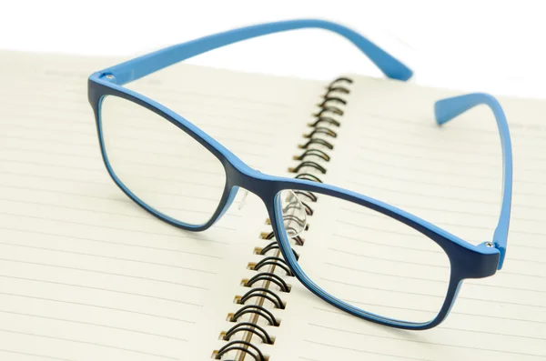 Gafas graduadas en un bloc de notas de papel en blanco . —  Fotos de Stock