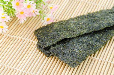 Bambu hasır üzerinde kızarmış deniz yosunu.