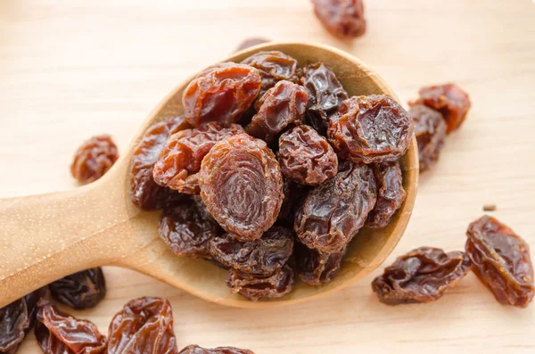 Red raisins in wooden spoon — Stock Photo, Image