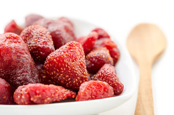 Getrocknete Erdbeeren in weißer Schüssel und Holzlöffel. — Stockfoto