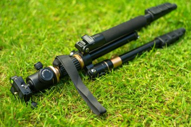Yeşil çimlerin üzerinde fotoğraf ve video kamera için tripod