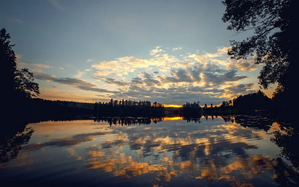 Crimson sunset on a forest lake, evening landscape