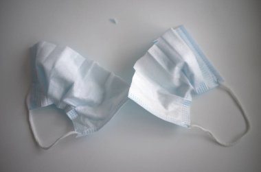 İkiye bölünmüş tıbbi maske, beyaz izole edilmiş.