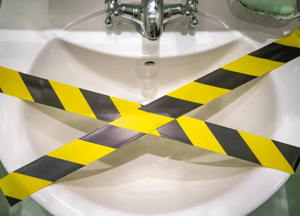 Musluğu olan beyaz bir lavabo yasak bir filmle kaplıdır. Su kullanmak yasaktır.!