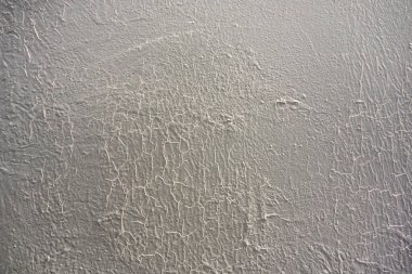 Yüzeydeki beyaz boya şişmiş ve çatlamış.