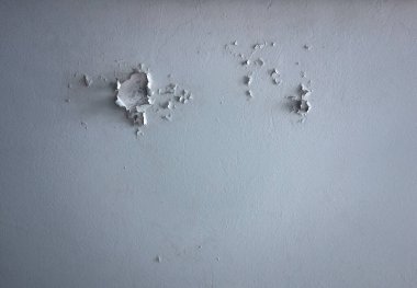 White ceiling with peeling paint and cracks, texture
