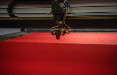 Lazer makinesi kırmızı kumaşın detaylarını keser