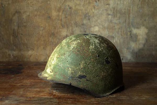Helmet of a soldier of the Soviet army during the Second World War. on a wooden table.