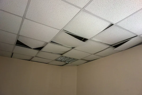 A broken square ceiling in an office space
