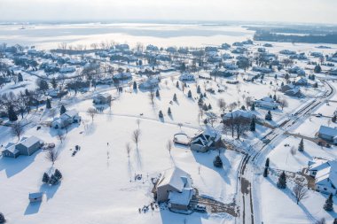 Taze kar yağdıktan hemen sonra banliyöde büyük bahçeli büyük evlerin üzerinde uçmak.