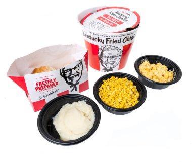 Winneconne, WI - 20 Haziran 2021: Bir paket KFC Kentucky Fried Chicken kova patates püresi, tüm kernal mısır ve peynirli Albay Sanders izole bir arka planda