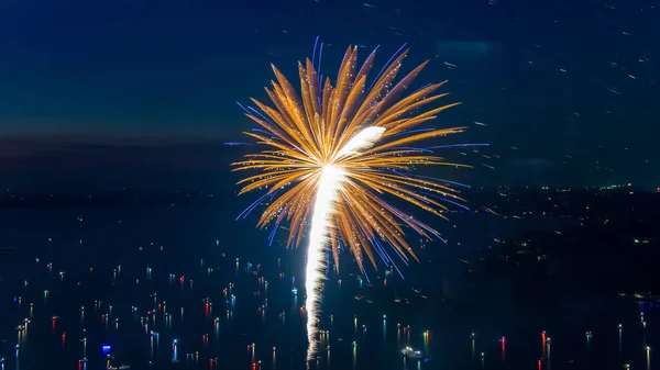 Fireworks on the forth of July fired from a barge on a lake taken with a drone.