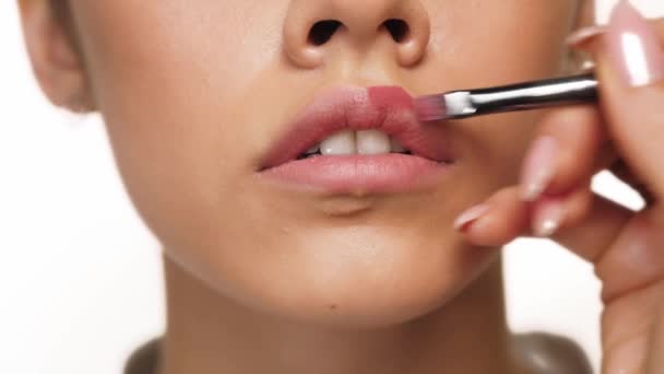 Labios de belleza de maquillaje. Una hermosa chica con buena piel está haciendo maquillaje de labios — Vídeos de Stock