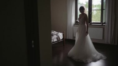 Güzel gelin yatak odasında gelinliğine hayran. Gelinlik içinde güzel bir gelin.