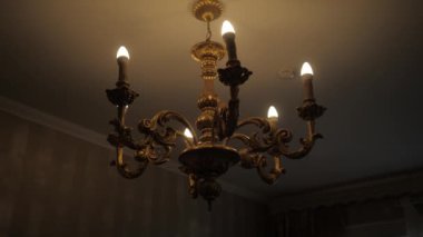 İçinde 6 ampul ve koyu bir iç mekan olan güzel bir klasik lamba..