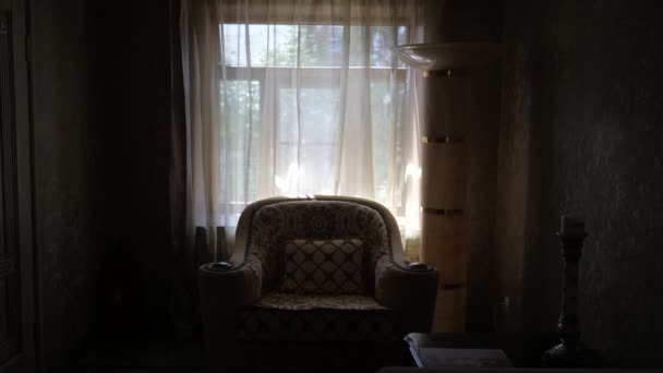 Dark interior with vintage armchair on the background of a window with curtains — Stock Video