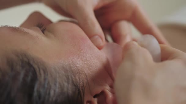 Massagem facial com pedras guache no spa. — Vídeo de Stock