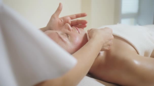 Massagem facial com pedras guache no spa. — Vídeo de Stock