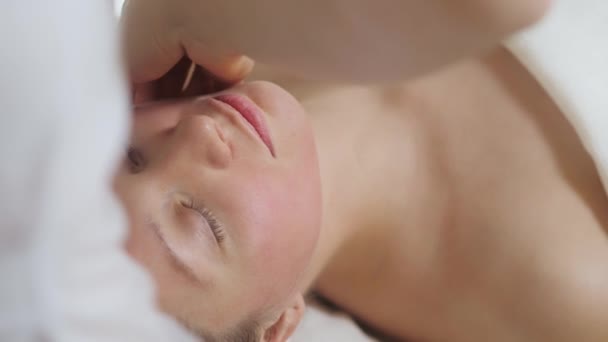 Leuke brunette vrouw op gezicht massage in spa salon. Wellness gezichtsmassage spa — Stockvideo