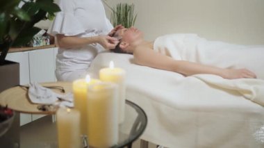 Şakak bölgesinin guaj taşlarıyla masaj yapan tatlı esmer..